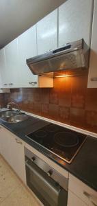 a kitchen with a stove and a sink at COBLANCA 20 - Fincas Arena in Benidorm +10 photos