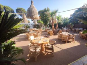 een patio met tafels, stoelen en bomen bij La Garoupe-Gardiole in Antibes
