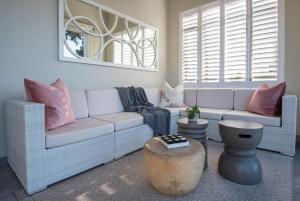 a living room with a white couch and pink pillows at The Clarendon - Fresnaye in Cape Town