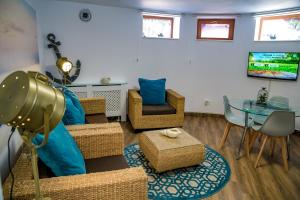 a living room with wicker chairs and a glass table at Villa Casafina Serviced Apartments in Mangalia