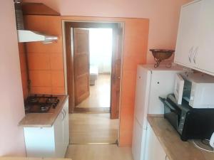 uma cozinha com paredes cor de laranja e um frigorífico branco em Apartament przy Wrocławskim Stadionie em Breslávia