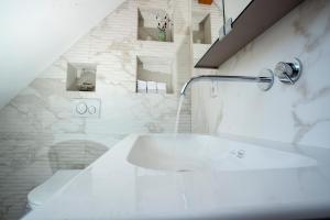 a white bathroom with a bath tub with a faucet at Pine Cone Loft on Baden-Baden's Panorama Trail in Baden-Baden