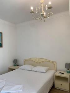 a bedroom with a white bed and a chandelier at Appartments near 7 km 5001155 in Odesa
