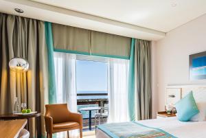 a hotel room with a bed and a view of the ocean at Crowne Plaza Limassol by IHG in Limassol