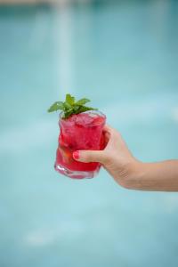 a hand holding a drink with a mint garnishment at Hotel Helios Lloret in Lloret de Mar