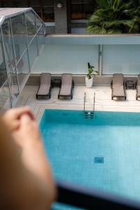una persona está mirando hacia abajo a una piscina en Hotel Helios Lloret, en Lloret de Mar
