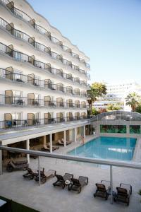 - un grand bâtiment avec une piscine en face dans l'établissement Hotel Helios Lloret, à Lloret de Mar