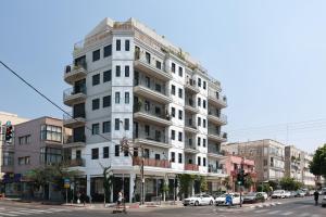 a tall white building on the corner of a street at Fabulous Corner Market by TLV2RENT in Tel Aviv