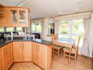 a kitchen with a table and a dining room at The Lodge in Llanelli