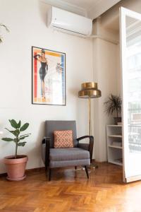 テッサロニキにあるAristotelous Square Apartmentのリビングルーム(椅子、植物付)