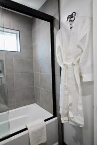 una bata blanca colgada en la puerta de una ducha en el baño en Los Angeles 3BR Villa Suites with Free Parking, en Los Ángeles