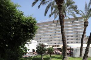 a hotel with palm trees in front of it at Helios Benidorm in Benidorm