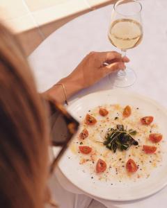 a woman holding a plate of food and a glass of wine at Helios Benidorm in Benidorm
