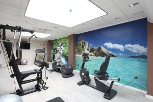 un gimnasio con equipamiento de ejercicio y un mural del océano en Helios Benidorm en Benidorm
