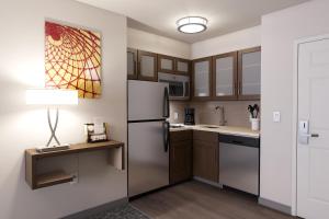 a kitchen with a refrigerator and a table with a lamp at Staybridge Suites Quantico-Stafford, an IHG Hotel in Stafford