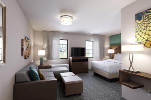 a hotel room with a bed and a couch at Staybridge Suites Quantico-Stafford, an IHG Hotel in Stafford