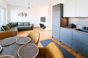a living room with a table and chairs and a kitchen at Lake View Suite in Mörbisch am See