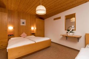 - une chambre avec un grand lit et un miroir dans l'établissement Villa Resi Apartments, à Corvara in Badia