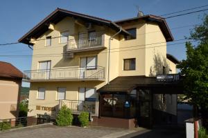 a large yellow building with a balcony at Apartmani i Bungalovi TROJKA in Banja Luka