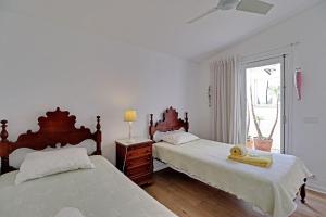 a bedroom with two beds and a window at Vilamoura Golf Villa 1 by Homing in Vilamoura