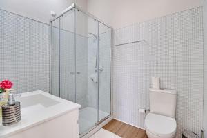 a white bathroom with a shower and a toilet at Vilamoura Golf Villa 1 With Pool by Homing in Vilamoura +17 photos