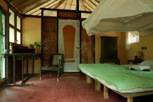 a bedroom with a bed and a desk in a room at Khaama Kethna Eco Sustainable Village in Agonda