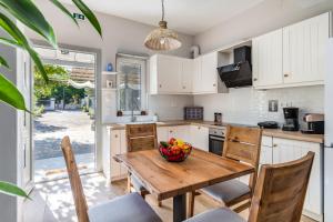 a kitchen with a wooden table with a bowl of fruit on it at Artemis' Garden in Skopelos Town