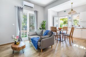 a living room with a couch and a table at Artemis' Garden in Skopelos Town +87 photos
