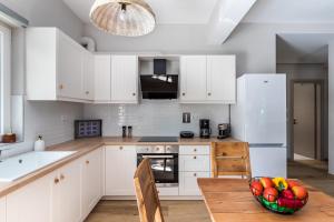 a kitchen with white cabinets and a bowl of fruit on a wooden table at Artemis' Garden in Skopelos Town