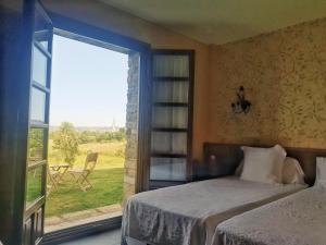 1 dormitorio con cama y ventana grande en Hotel Rural Casona de Cefontes, en Cefontes
