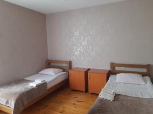 2 letti in una piccola camera con pavimenti in legno di Kera Guest House a Kazbegi