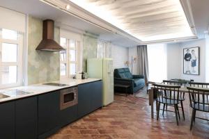 a kitchen with a refrigerator and a table with chairs at Espacio para 6 en el centro Wifi gratis in Logroño