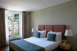 a bedroom with a large bed with a large window at Grand Hotel Portovenere in Portovenere