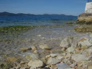 un grupo de rocas en la orilla de un cuerpo de agua en Apartments Ivanka, en Zadar