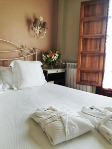 a bedroom with a bed with two towels on it at Hotel Rural Casona de Cefontes in Cefontes