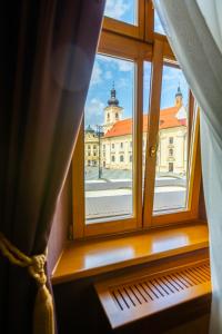 une fenêtre ouverte avec vue sur un bâtiment dans l'établissement Hotel Am Ring, à Sibiu