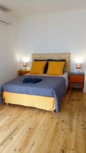 a bedroom with a large bed with yellow pillows at La Vigneronne in Villelongue-dʼAude