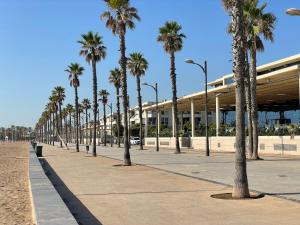 a row of palm trees in front of a building at M & B Beach Apartment in Valencia