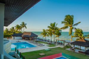 an aerial view of a resort with a swimming pool and the ocean at Cahy Praia Hotel in Prado