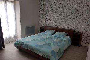 1 dormitorio con 1 cama con edredón azul en Aubaterra, en Aubeterre-sur-Dronne