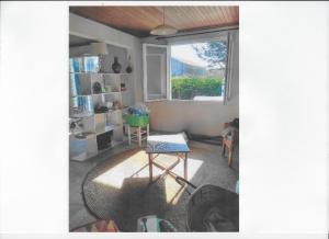 ein Wohnzimmer mit einem Stuhl und einem Fenster in der Unterkunft Maison oléronaise avec la plage à pied et la piste cyclable au bout du jardin in Dolus d'Oléron