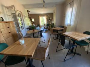 une salle à manger avec des tables et des chaises en bois dans l'établissement Chambres d'Hôtes La Bastide St Julien, à Anduze