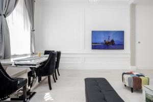 een woonkamer met een tafel en stoelen en een schilderij bij Oxford Street 2 Bed Apartment in Londen