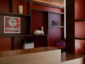 ein Ankleidezimmer mit roten Wänden und einem Holztisch in der Unterkunft Eos Hotel in Lecce