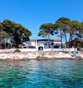 une maison sur la rive d'une masse d'eau dans l'établissement SilbaBlu Bed & Breakfast, à Silba