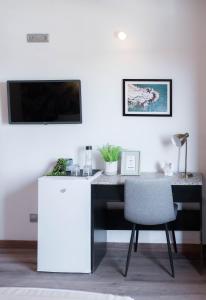 a desk with a chair and a television on a wall at Hotel Ventus in El Médano