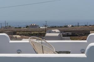 une balustrade blanche avec une chaise sur le toit dans l'établissement Kyklos Villas - luxury villas with private pool, à Karterados