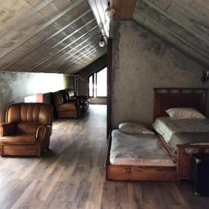 サン・ヴィセンテにあるA Casa Estrelícia-Dourada Garcêsのベッドルーム1室(ベッド2台、ソファ、椅子付)