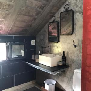 a bathroom with a sink and two mirrors on the wall at A Casa Estrelícia-Dourada Garcês in São Vicente
