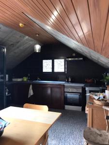 a kitchen with black walls and a wooden ceiling at A Casa Estrelícia-Dourada Garcês in São Vicente